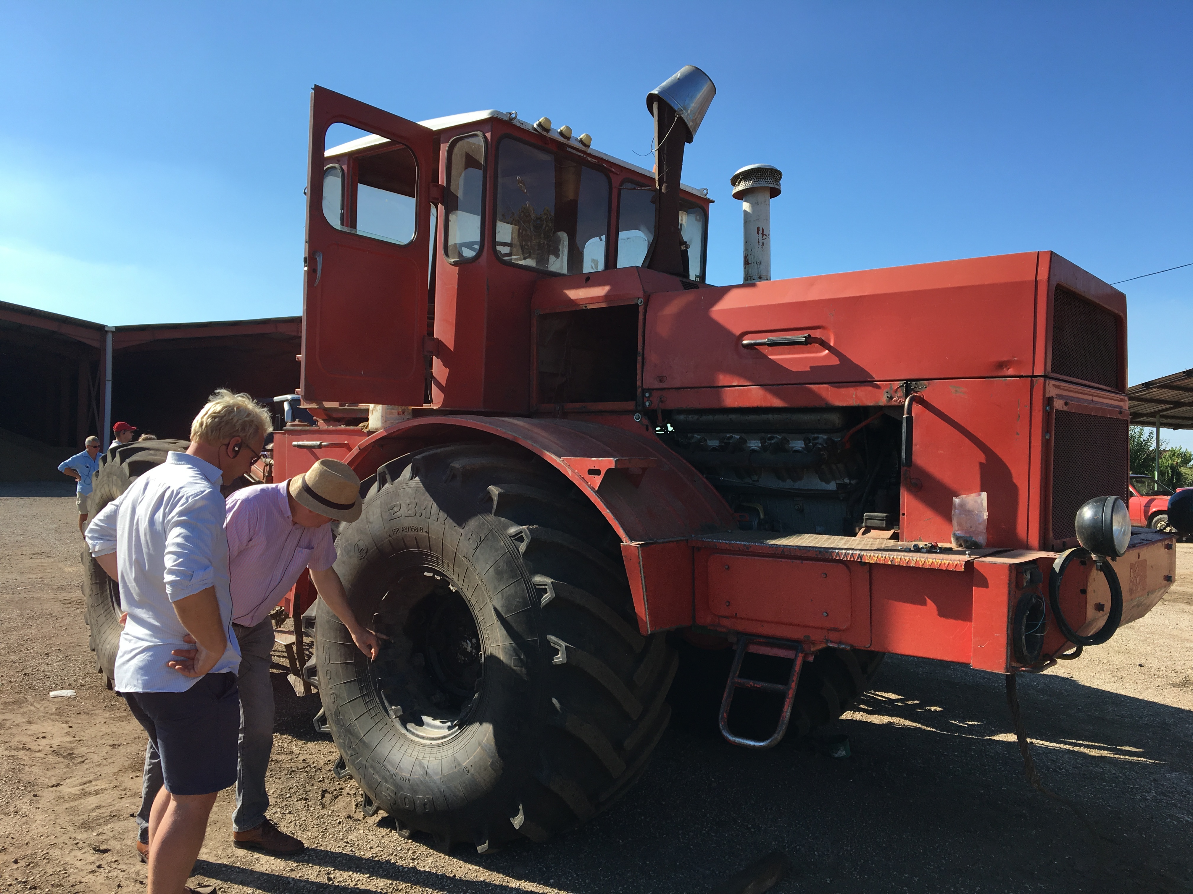 a couple of people standing next to a tractor